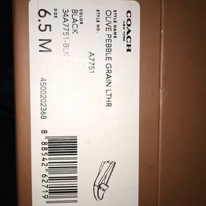 A pair of black leather coach shoes.